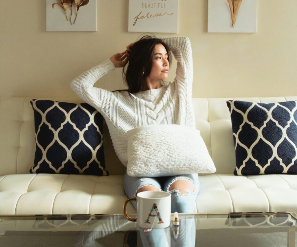 Woman sitting on sofa looking to the side contemplating